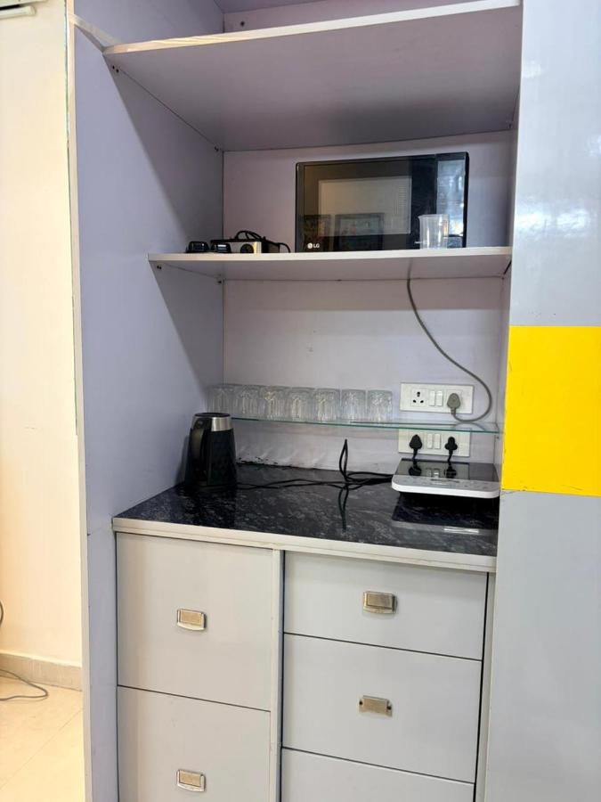 Kitchenette with a microwave, electric kettle, induction hob, glassware and drawers