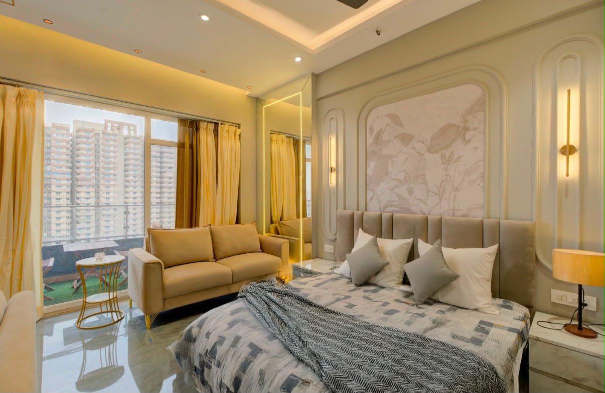 Studio bed with cushions and a throw, and a sofa by a large window looking onto the balcony